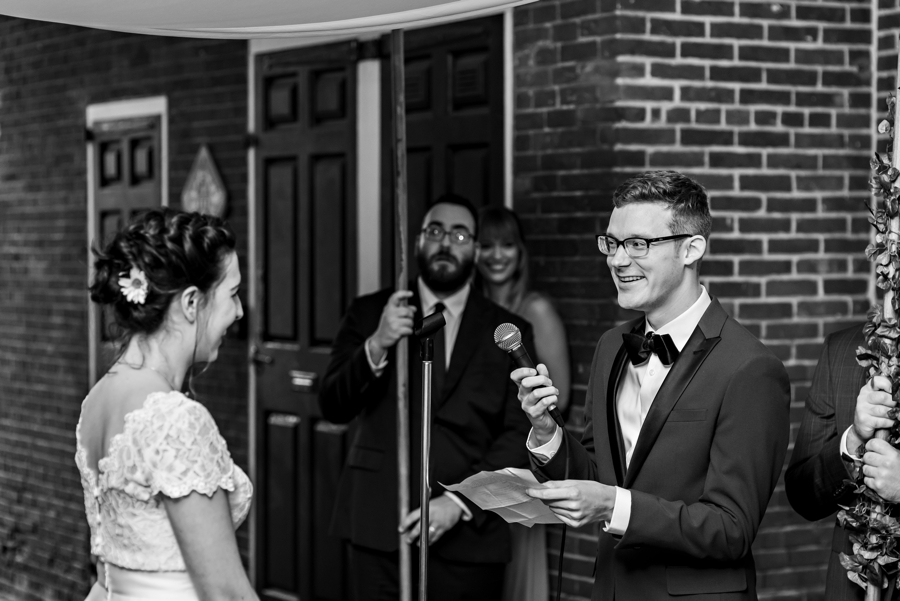 A groom reads his vows to his bride during their wedding ceremony.